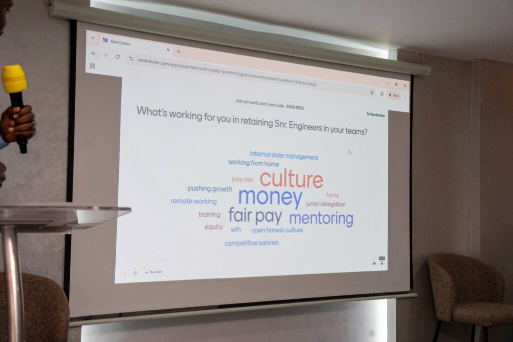 Conference slide projection discussing tech marketing insights and retention of senior engineering talent; Carolyne Mweberi