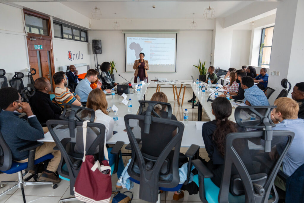 Dr. Shiko Gitau, CEO of Qhala, presents on AI ecosystem in Kenya at PEDL workshop, with Carolyne Mweberi and attendees listening.